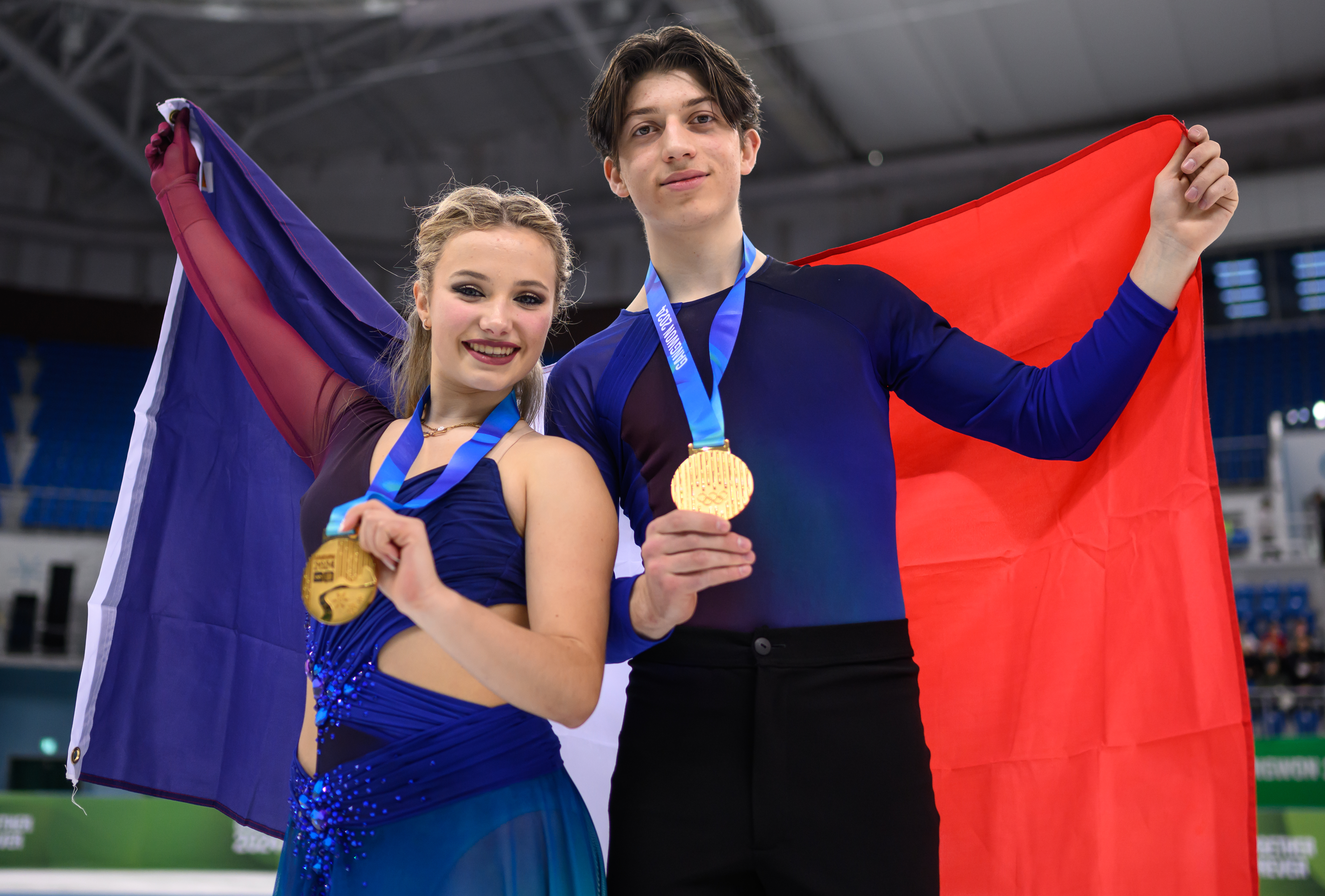 Gold medalists Ambre Perrier Gianesini (FRA) and Samuel Blanc Klaperman (FRA) on the ice with their national flag after the medal ceremony for the Ice Dance